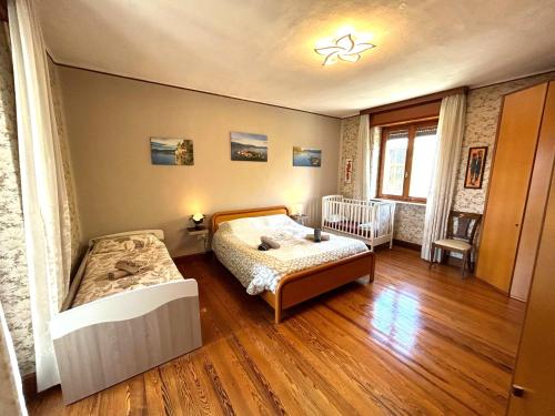 a bedroom with a bed and a crib in it at Lago Maggiore Green House in Leggiuno