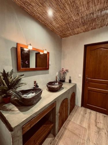 a bathroom with two sinks on a counter at Nature, évasion, jacuzzi, grande piscine et cinéma in Houdancourt