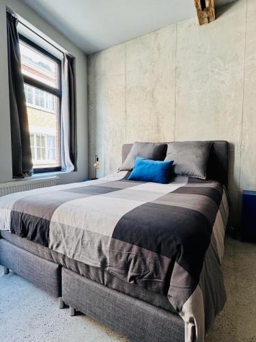 a bedroom with a large bed with a blue pillow on it at DinLoft in Dinant