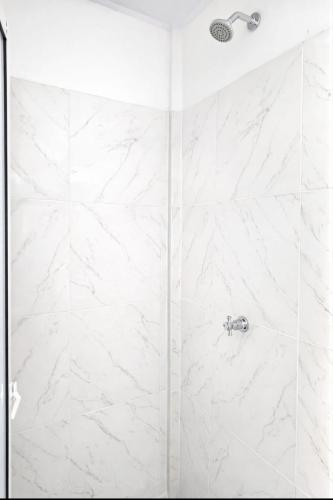 a bathroom with a shower with white marble at Aquitania in Rincón