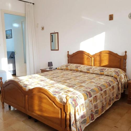a bedroom with a wooden bed in a room at Casa Aloe by My Home Apulia in Torre Lapillo
