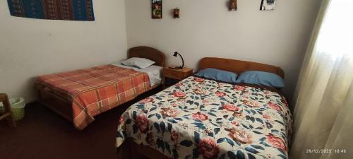 a bedroom with two beds at Casa El Capulí in Cajamarca