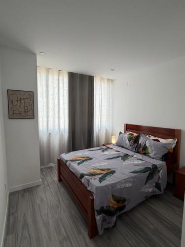 a bedroom with a bed with a bedspread on it at Ocean Palm Apartments II - Edifício Paradis- Cidadela in Praia
