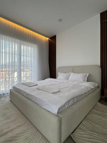 a large bed in a bedroom with a large window at Sorelle Hotel in Prizren