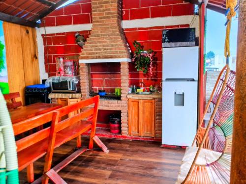 a kitchen with a table and a stove and a refrigerator at CABAÑA tipo habitación planta alta en Zacatlàn in Zacatlán