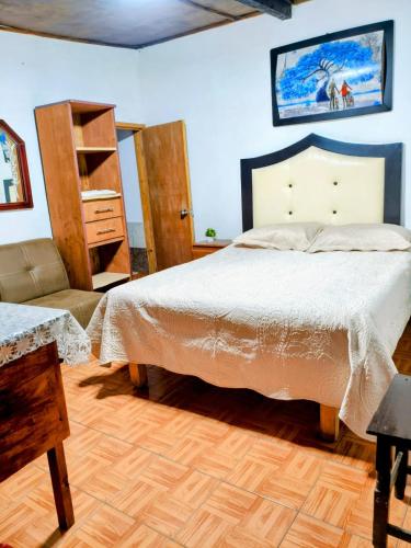 a bedroom with a bed and a chair at CABAÑA tipo habitación planta alta en Zacatlàn in Zacatlán