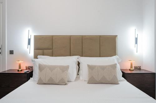 a bedroom with a large bed with white pillows at Poolside and Garden Apartments Golem Beach in Golem