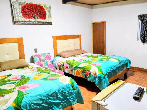 a room with two beds and a desk with a computer at CABAÑA tipo habitación con PALAPA y Asador Planta Alta en Zacatlán in Zacatlán