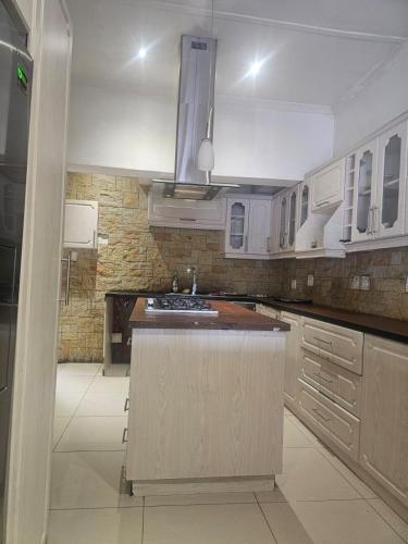 a kitchen with white cabinets and a island in it at Ludinz Self Catering Accommodation Bellville in Avondale