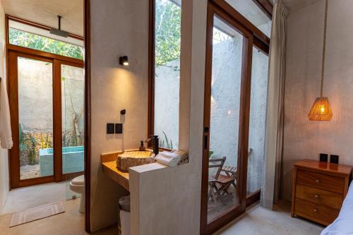 a bathroom with a sink and a toilet and a mirror at Casa Calma 45 in Mérida