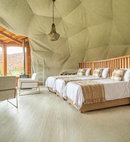 a bedroom with a large bed with aamed ceilings at Bonanza Glamp Nature Experience in El Chalten