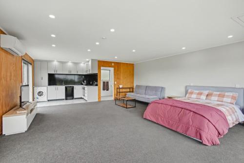 a large bedroom with a bed and a couch at The Little Hive in Westport
