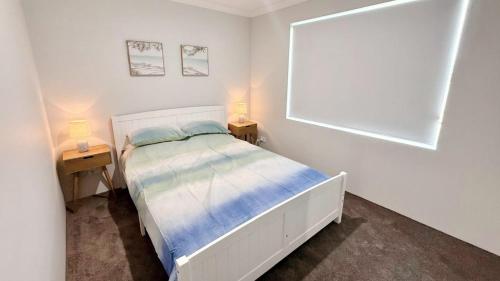 a white bedroom with a bed and two night stands at Eagle Breeze in Eaton