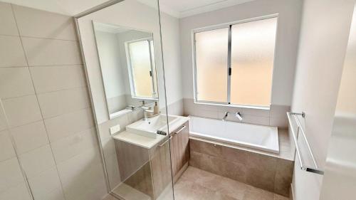 a bathroom with a tub and a sink and a mirror at Eagle Breeze in Eaton