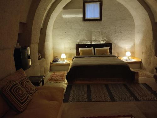 a bedroom with a bed and a couch at Route Cappadocia in Avanos