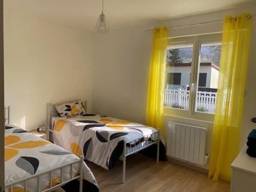 a bedroom with two beds and a window with yellow curtains at Le rendez-vous des 2 amants in Romilly-sur-Andelle