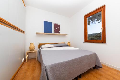a bedroom with a bed and a window at L13 Terrazza Levante in Stintino