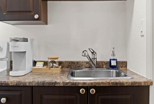 a kitchen counter with a sink and a coffee maker at Lakeside Villa & Nordic Spa in Penticton