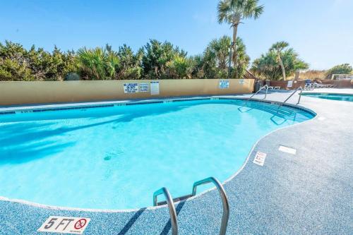 a large swimming pool in a resort with palm trees at Amazing Oceanfront Accessible Beach Amazing View in Myrtle Beach