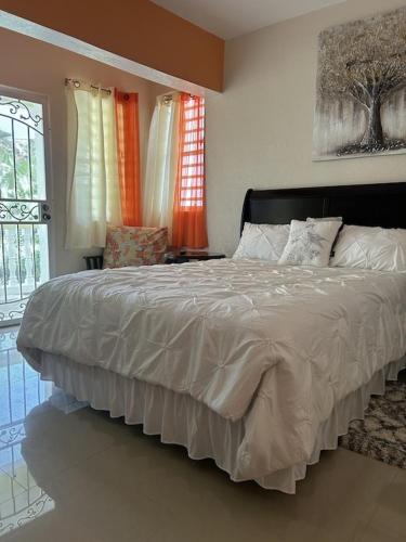 a bedroom with a large bed and two windows at Zoë Oasis - #1 Couple's Choice & Wholesome Getaway in Lilliendahl