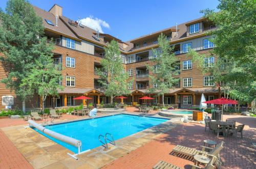 a pool at a hotel with tables and chairs at River Run Village by Vail Resorts in Keystone