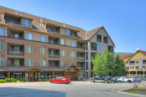 a large building with cars parked in a parking lot at River Run Village by Vail Resorts in Keystone