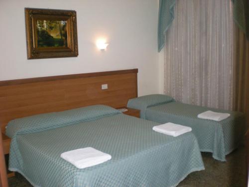ローマにあるRitmo Blues B&Bのベッド2台と鏡が備わるホテルルームです。