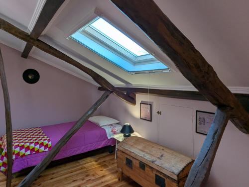 a bedroom with a purple bed and a skylight at quarto duplo downtown in Ponta Delgada