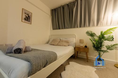 a bedroom with two beds and a plant in it at Central Manchester Duplex - Balcony - Roof Terrace - Parking in Manchester