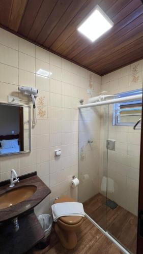 a bathroom with a toilet and a sink and a shower at Pousada Mar de Ubatuba - Itaguá in Ubatuba