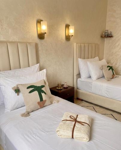 a hotel room with two beds with white sheets at Marrakech in Marrakesh