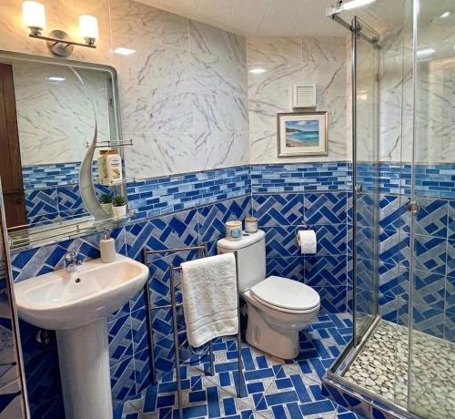 a blue and white bathroom with a toilet and a sink at Marrakech in Marrakesh