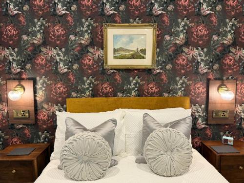 a bedroom with a bed with a floral wallpaper at MacDonald Arms Hotel in Tobermory