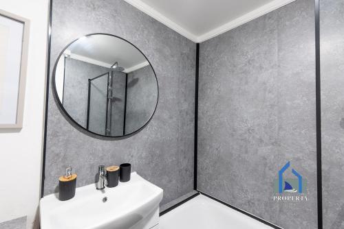 a bathroom with a sink and a mirror at Traditional Central Home-Games Room-Free Parking in Manchester