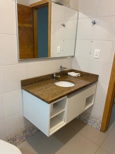 a bathroom with a sink and a mirror at 101 - Saint Sebastian Flat in Jaraguá do Sul