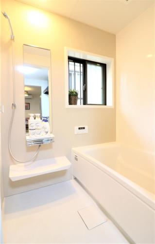 a bathroom with a tub and a sink and a mirror at Residencial Hotel EK1 in Fujisawa