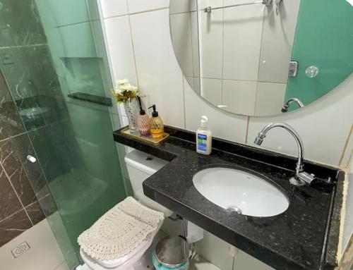 a bathroom with a sink and a mirror and a toilet at Quarto 1 próximo ao Aeroporto Internacional in Belém