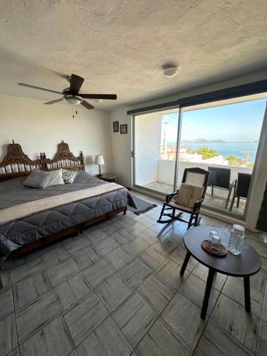 a bedroom with a bed and a view of the ocean at Villa Centenario in Mazatlán