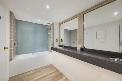 a bathroom with two sinks and a large mirror at Holiday Inn Birmingham Bromsgrove by IHG in Bromsgrove