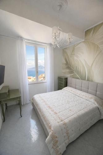 a white bedroom with a large bed and a window at Panoramic Apartment Sea & Vesuvio View, Sorrento Center, COSTA DEL SOLE in Sorrento