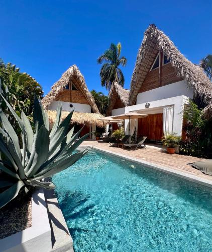 a villa with a swimming pool and a house at Leeloo Boutique Hotel in Las Terrenas