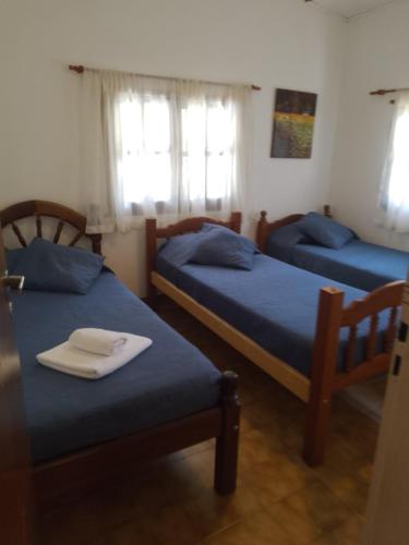 a room with two beds with blue sheets at Otto's Haus in Villa General Belgrano