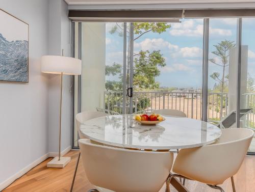 a dining room with a glass table and white chairs at Salt Beach Resort Apartments by Kingscliff Accommodation in Kingscliff