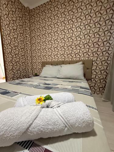 a bedroom with a bed with a flower on it at Apto Serras Gerais 2 in Dianópolis