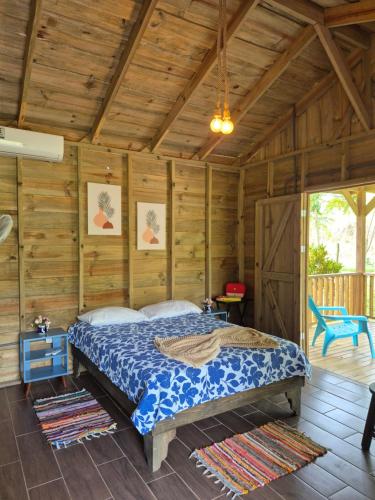 a bedroom with a bed in a room with wooden walls at Cabañas Bambú Pérez Zeledón in San Isidro de El General