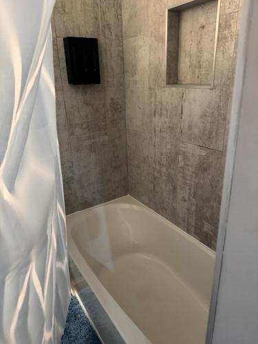 a shower with a white tub in a bathroom at 2BR Spacious Escape Close to DC & Baltimore in Laurel