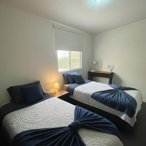 two beds in a bedroom with a window at suite doble ejecutiva providencia in Guadalajara