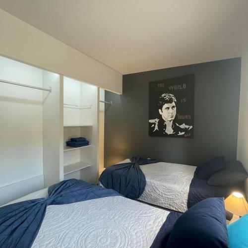 a bedroom with two beds and a poster on the wall at suite doble ejecutiva providencia in Guadalajara