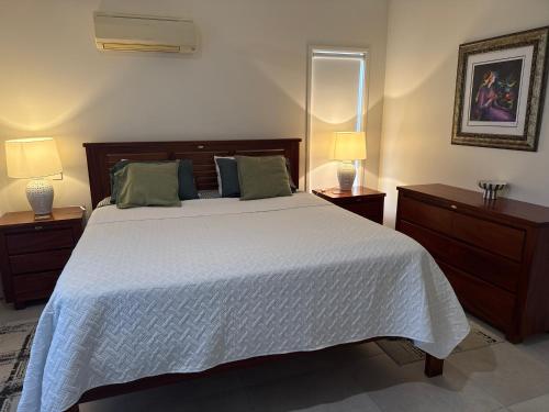 a bedroom with a large white bed with two night stands at Luxury Newport canal king suite home in Redcliffe