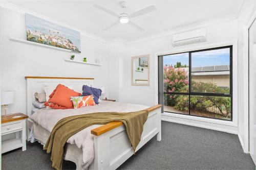 a bedroom with a bed and a large window at Echo Waves in Kiama